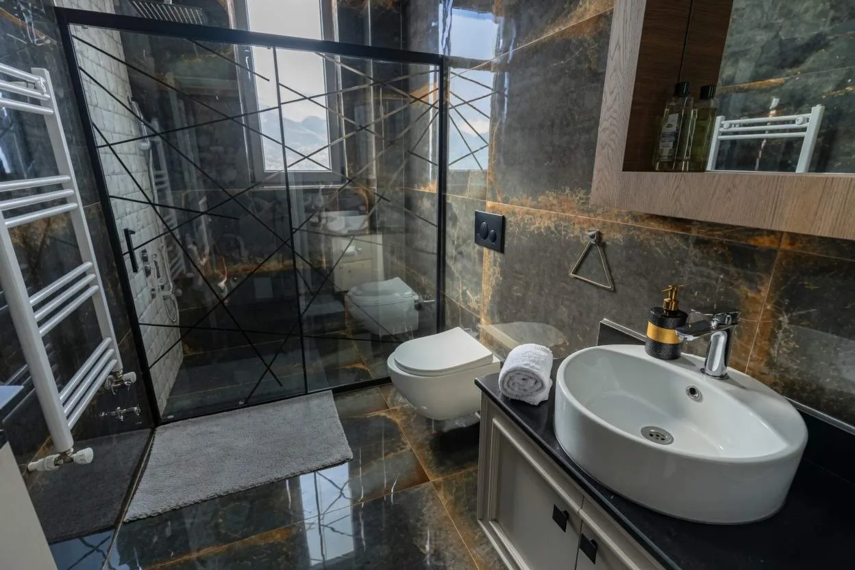 Bathroom in amber-veined dark stone with rainfall shower